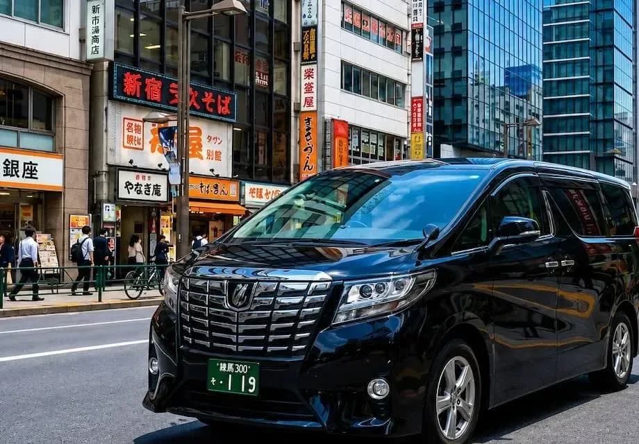 Toyota Alphard hitam dengan sopir pribadi di jalanan Tokyo, Jepang
